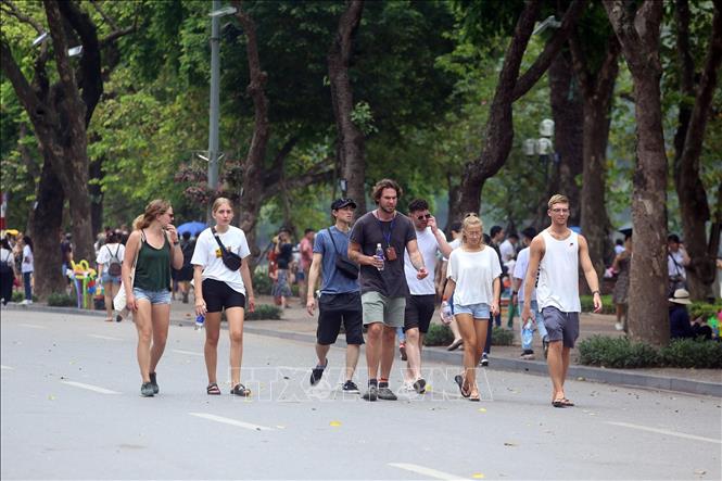 Trong ảnh: Khách du lịch nước ngoài tham quan phố đi bộ Hồ Gươm. Ảnh: Huy Hùng - TTXVN