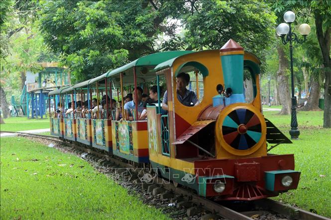 Trong ảnh: Người dân đi tàu điện vòng quanh khu vực hồ Bảy Mẫu, Công viên Thống Nhất. Ảnh: Huy Hùng - TTXVN