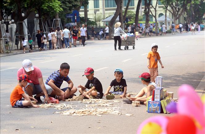 Trong ảnh: Các em nhỏ vui chơi trên phố đi bộ Hồ Gươm thu hút khách. Ảnh: Huy Hùng - TTXVN