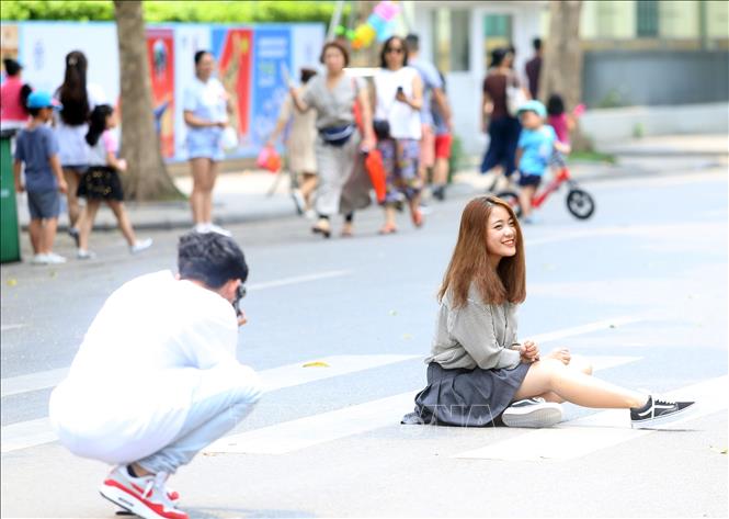 Trong ảnh: Đôi bạn trẻ chụp ảnh lưu niệm trên phố đi bộ Hồ Gươm thu hút khách. Ảnh: Huy Hùng - TTXVN