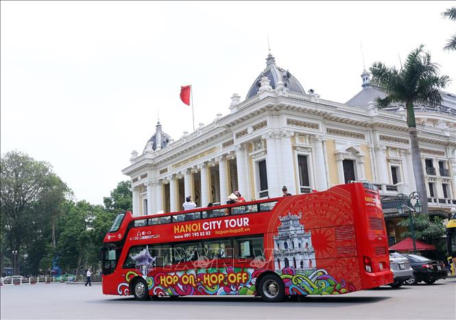 Trong ảnh: Đi xe buýt thăm quan thành phố thu hút du khách trong các ngày nghỉ lễ. Ảnh: Huy Hùng - TTXVN