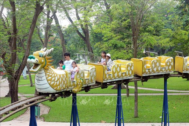 Trong ảnh: Các gia đình cho trẻ nhỏ tham gia các trò chơi tại các điểm công cộng của Thủ đô. Ảnh: Huy Hùng - TTXVN