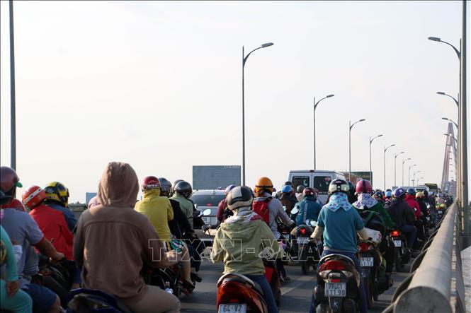 Trong ảnh: Các phương tiện chen nhau nhích từng chút trên cầu Rạch Miễu. Ảnh: Trần Thị Thu Hiền – TTXVN 