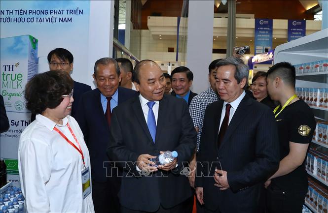 Trong ảnh: Thủ tướng Nguyễn Xuân Phúc và đại biểu tham quan các gian trưng bày tại Triển lãm Thành tựu kinh tế tư nhân. Ảnh: Thống Nhất – TTXVN

