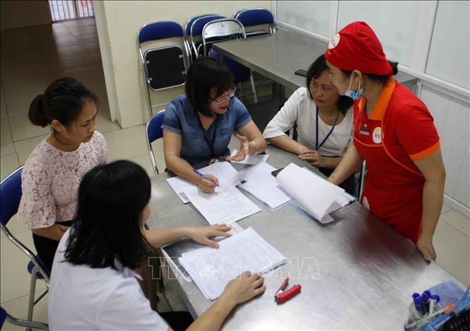 Trong ảnh: Ban An toàn thực phẩm của Trường Tiểu học Phương Liên thực hiện đánh giá, ký biên bản sau khi hoàn tất công tác giao nhận thực phẩm hàng ngày. Ảnh: Thanh Tùng-TTXVN