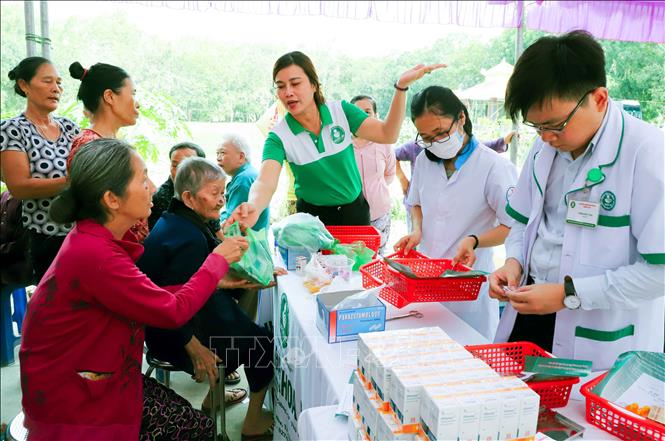 Các nhân viên của Bệnh viện đa khoa Medic Bình Dương phát thuốc miễn phí cho người nghèo ở xã Minh Tân, huyện Dầu Tiếng, Bình Dương. Ảnh: Nguyễn Văn Việt-TTXVN