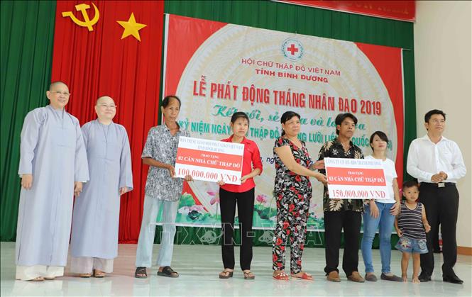 Đại diện các hộ nghèo có khó khăn về nhà ở nhận sự hỗ trợ về xây nhà Chữ thập đỏ của các tổ chức, cá nhân có tấm lòng vàng. Ảnh: Nguyễn Văn Việt-TTXVN