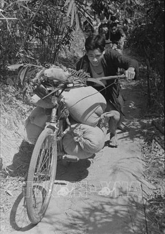 Trong ảnh: Đoàn xe thồ vận chuyển lương thực, vũ khí trên đường Trường Sơn, đoạn qua tỉnh Quảng Bình những ngày đầu mở đường. Thời gian đầu khai phá tuyến đường, bộ đội ta đã bí mật vạch tuyến đi qua những vùng núi hiểm trở, cheo leo với khẩu hiệu “Đi không dấu, nấu không khói, nói không tiếng”. Ảnh: Hữu Ngôi - TTXVN