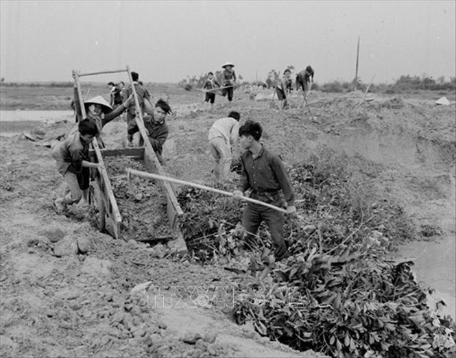 Trong ảnh: Lực lượng dân công hỏa tuyến lấp hố bom, san đường, đảm bảo thông xe liên tục. Ảnh: Hồ Ca - TTXVN