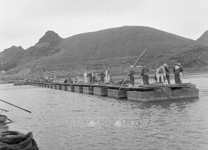 Trong ảnh: Đội Thanh niên xung phong 296 Thanh Hóa lắp cầu phao bến phà Hàm Rồng qua sông Mã. Ảnh: Văn Sắc - TTXVN
