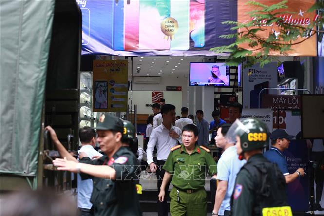 Trong ảnh: Cảnh sát kiểm tra, khám xét cửa hàng điện thoại Nhật Cường mobile ở 33 Lý Quốc Sư, Hà Nội. Ảnh: Doãn Tấn - TTXVN