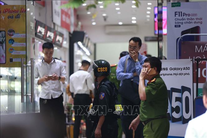 Trong ảnh: Cảnh sát kiểm tra, khám xét tại cửa hàng điện thoại Nhật Cường mobile ở 33 Lý Quốc Sư, Hà Nội. Ảnh: Doãn Tấn - TTXVN