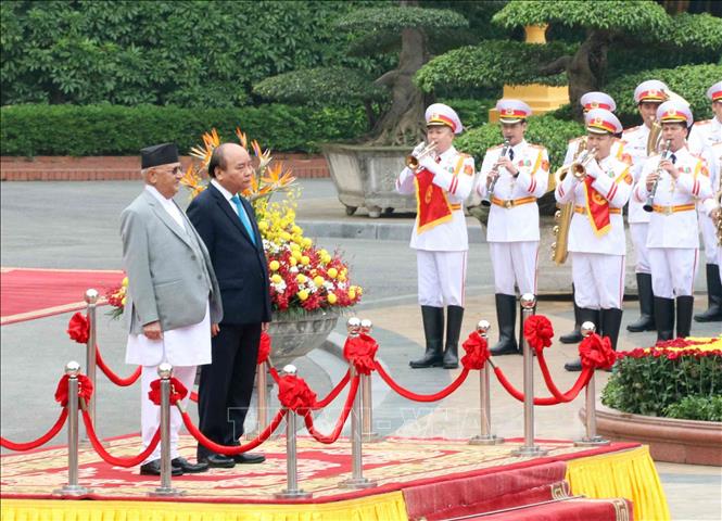 Trong ảnh: Thủ tướng Nguyễn Xuân Phúc và Thủ tướng Nepal K.P. Sharma Oli trên bục danh dự, thực hiện nghi lễ chào cờ. Ảnh: Văn Điệp – TTXVN