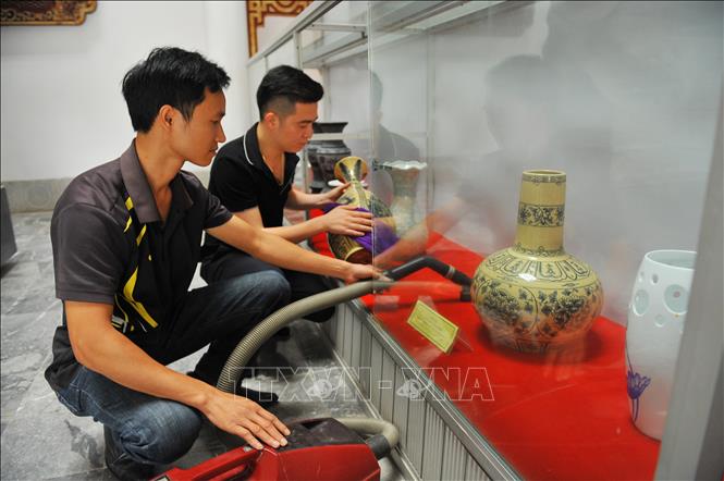 Trong ảnh: Các cán bộ của bảo tàng kiểm tra và vệ sinh các hiện vật. Ảnh: Minh Đức - TTXVN