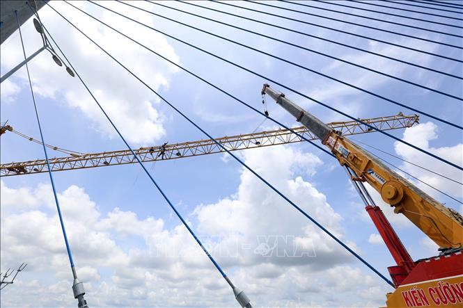 Trong ảnh: Các nhà thầu đang khẩn trương tháo dỡ các trụ tháp tại cầu Vàm Cống trước ngày thông xe. Ảnh: Huy Hùng - TTXVN