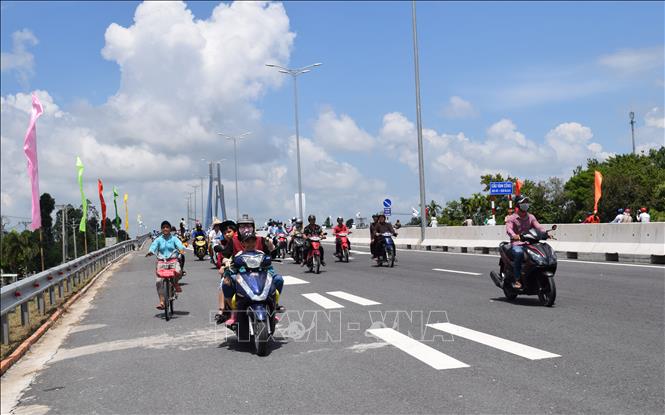 Trong ảnh: Người dân vui mừng khi cầu Vàm Cống nối nhịp đôi bờ sông Hậu. Ảnh: Chương Đài - TTXVN