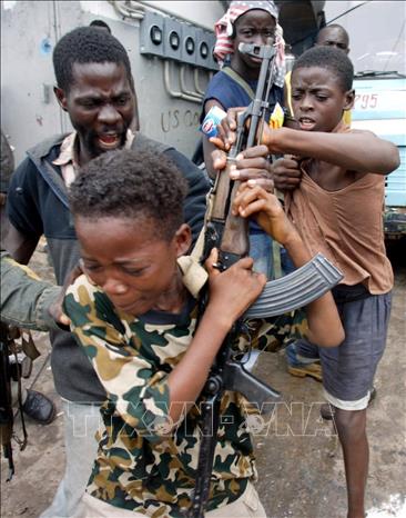 Trong ảnh: Trẻ em Liberia bị ép cầm súng cho lực lượng phiến quân LURD tại khu vực Freeport ở Monrovia, ngày 5/8/2003. Ảnh: AFP/TTXVN phát