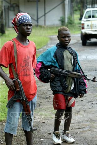 Trong ảnh: Trẻ em bị ép cầm súng cho lực lượng phiến quân tại khu vực quận Buchanan, Liberia, ngày 29/8/2003. Ảnh: AFP/TTXVN phát