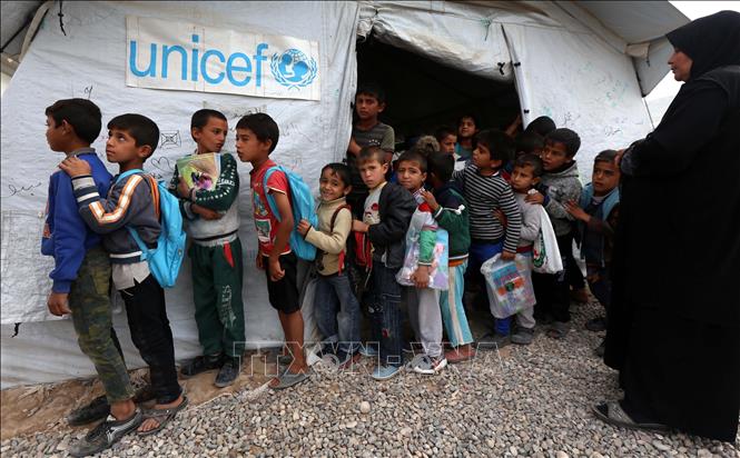 Trong ảnh: Trẻ em tị nạn Iraq xếp hàng bên ngoài một trường học của Liên hợp quốc tại trại tị nạn Hasan Sham, cách Arbil, miền Bắc Iraq 40km về phía Đông. Ảnh: AFP/TTXVN phát