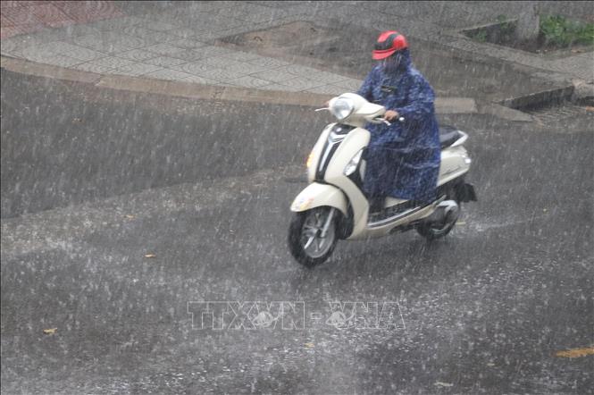 Trong ảnh: Người dân đi lại dưới mưa lớn trên một con đường ở thành phố Đông Hà. Ảnh: Nguyên Lý-TTXVN