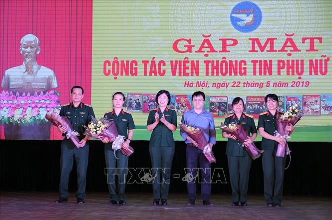 Trong ảnh: Thượng tá Phùng Thị Phú, Trưởng Ban Phụ nữ Quân đội tặng hoa cho các đại biểu khách mời tham dự tọa đàm. Ảnh: Dương Giang - TTXVN