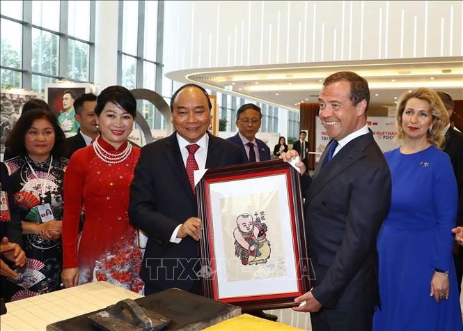Trong ảnh: Thủ tướng Nguyễn Xuân Phúc tặng bức tranh “em bé ôm gà” cho Thủ tướng Dmitri Medvedev. Ảnh: Thống Nhất – TTXVN