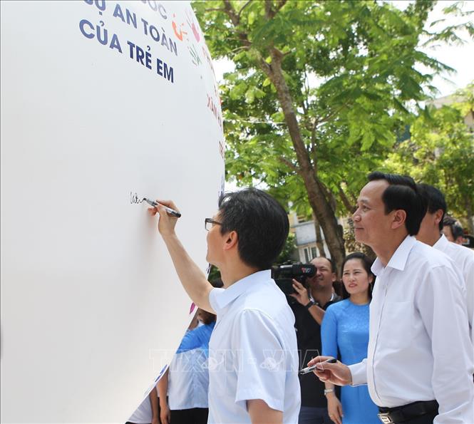 Trong ảnh: Phó Thủ tướng Chính phủ Vũ Đức Đam ký tên lên quả cầu phát động Tháng hành động vì trẻ em. Ảnh: Thanh Tùng-TTXVN