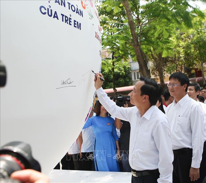 Trong ảnh: Bộ trưởng Bộ Lao động - Thương binh và Xã hội Đào Ngọc Dung ký tên lên quả cầu phát động Tháng hành động vì trẻ em. Ảnh: Thanh Tùng-TTXVN
