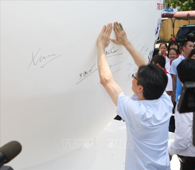 Trong ảnh: Phó Thủ tướng Chính phủ Vũ Đức Đam in dấu tay lên quả cầu phát động Tháng hành động vì trẻ em 2019. Ảnh: Thanh Tùng-TTXVN