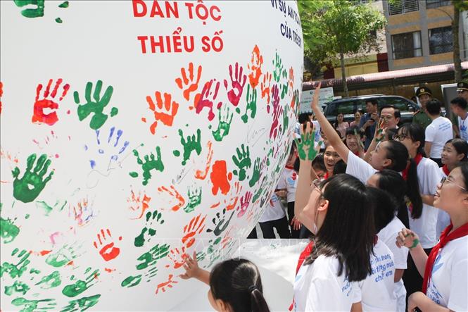 Trong ảnh: Các em học sinh in dấu tay lên quả cầu phát động Tháng hành động vì trẻ em. Ảnh: Thanh Tùng-TTXVN