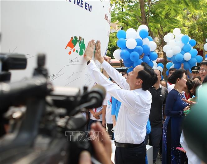 Trong ảnh: Bộ trưởng Bộ Lao động - Thương binh và Xã hội Đào Ngọc Dung in dấu tay lên quả cầu phát động Tháng hành động vì trẻ em 2019. Ảnh: Thanh Tùng-TTXVN