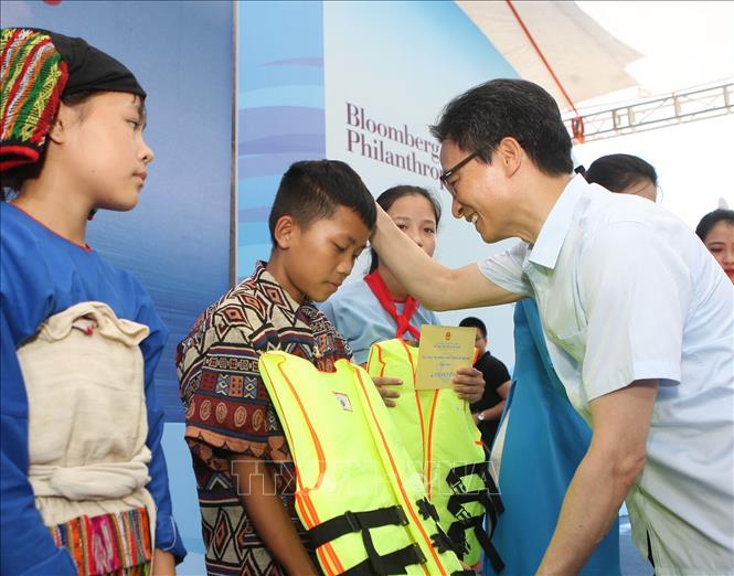 Trong ảnh: Phó Thủ tướng Chính phủ Vũ Đức Đam tặng áo phao cho các em nhỏ tại buổi lễ. Ảnh: Thanh Tùng-TTXVN