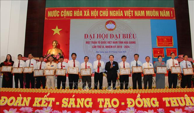 Trong ảnh: Đại diện các tập thể có thành tích xuất sắc trong thực hiện công tác mặt trận nhiệm kỳ 2014 - 2019 nhận Bằng khen của UBND tỉnh Hậu Giang. Ảnh: Hồng Thái - TTXVN