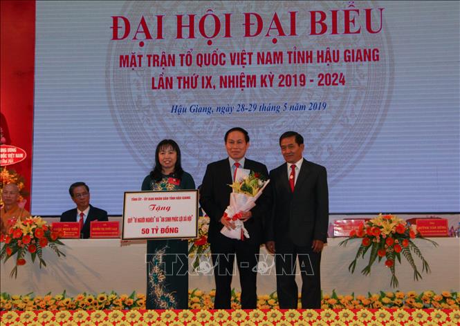 Trong ảnh: Đại diện Uỷ ban Mặt trận Tổ quốc Việt Nam tỉnh Hậu Giang nhận bảng tượng trưng đóng góp Quỹ An sinh phúc lợi xã hội. Ảnh: Hồng Thái - TTXVN