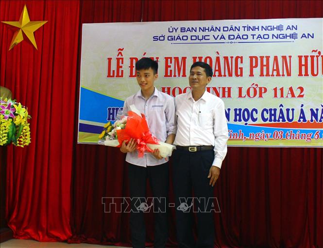 Trong ảnh: Lãnh đạo Sở Giáo dục và Đào tạo tỉnh Nghệ An tặng hoa chúc mừng em Hoàng Phan Hữu Đức. Ảnh: Tá Chuyên – TTXVN