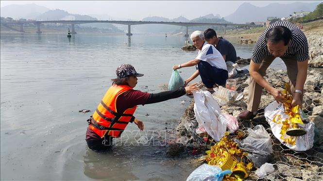 Trong ảnh: Người dân thành phố Hòa Bình, tỉnh Hòa Bình đi thu gom túi ni lông vứt trên sông Đà trong ngày Tết Táo quân để bảo vệ môi trường. Ảnh: Thanh Hải – TTXVN