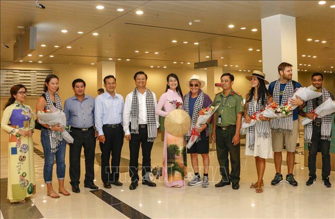 Trong ảnh: Tỷ phú Joe Lewis và các thành viên trong đoàn chụp ảnh cùng lãnh đạo UBND thành phố Cần Thơ. Ảnh: Thanh Liêm - TTXVN