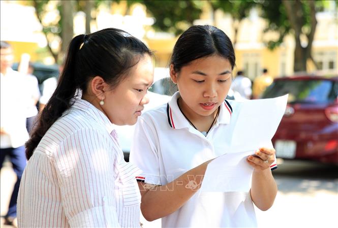 Trong ảnh: Thí sinh trao đổi về bài thi môn Toán tại điểm thi Trường THPT Lê Viết Thuật. Ảnh: Bích Huệ - TTXVN