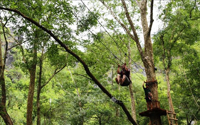 Photo: A visitor enjoys rope sliding at Ozo Treetop Park. VNA Photo: Mạnh Thành