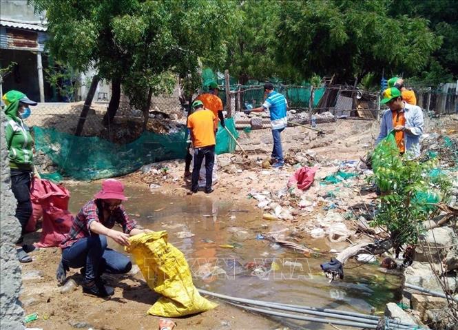 Trong ảnh: Đội xung kích tình nguyện tổ chức thu gom rác thải tại các khu dân cư. Ảnh: Công Thử - TTXVN