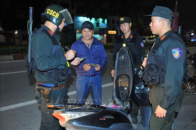 Trong ảnh: Các chiến sĩ CSCĐ kiểm tra hành chính người vi phạm luật khi tham gia giao thông. Ảnh: Minh Đức - TTXVN