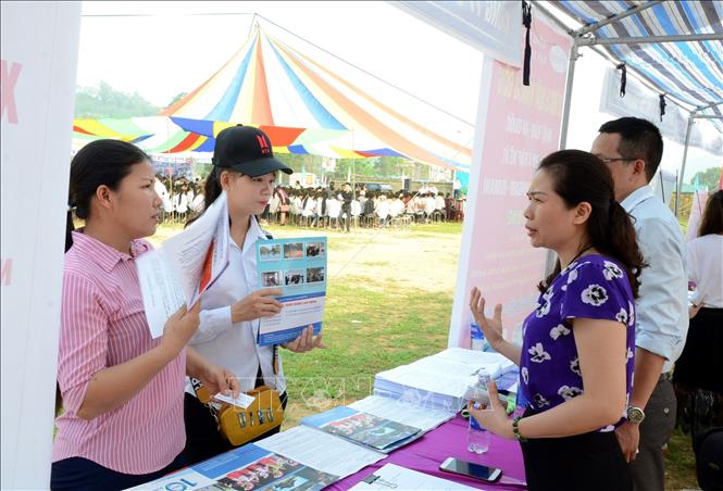 Các doanh nghiệp tuyển dụng lao động đi lao động nước ngoài tư vấn, giới thiệu người lao động các xã thuộc khu vực ATK Yên Sơn về thị trường xuất khẩu lao động của đơn vị. Ảnh: Quang Cường – TTXVN.