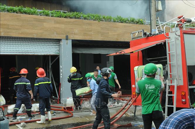 Trong ảnh: Tới 9 giờ sáng 17/6/2019, lực lượng chức năng vẫn đang dập lửa tàn, di chuyển tài sản tới nơi an toàn. Ảnh: Thành Chung – TTXVN 

