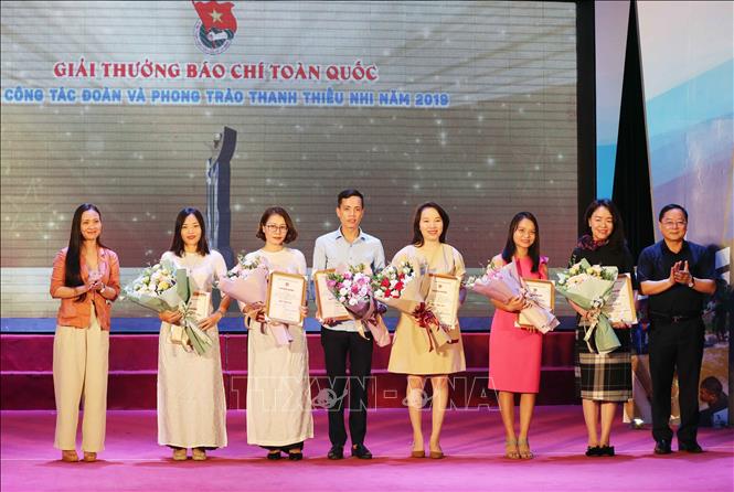 Trong ảnh: Ban Tổ chức tặng hoa và trao giải cho các tác giả đạt giải Ba. Ảnh: Doãn Tấn - TTXVN