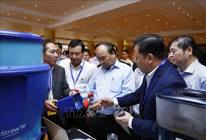 Trong ảnh: Thủ tướng Nguyễn Xuân Phúc và các đại biểu tham quan triển lãm công nghệ phòng chống thiên tai được trưng bày tại hội nghị. Ảnh: Thống Nhất -TTXVN  