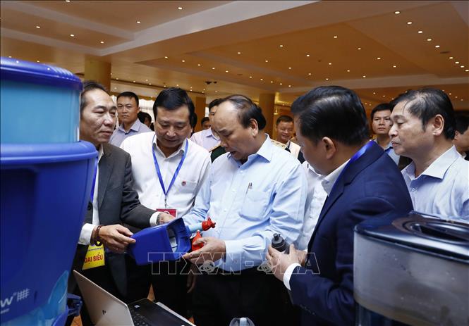 Trong ảnh: Thủ tướng Nguyễn Xuân Phúc và các đại biểu thăm quan triển lãm công nghệ phòng chống thiên tai được trưng bày tại hội nghị. Ảnh: Thống Nhất -TTXVN  
