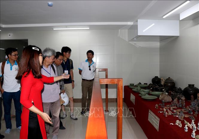 Photo: Visitors visit ancient pottery articles. VNA Photo: Sỹ Thắng 