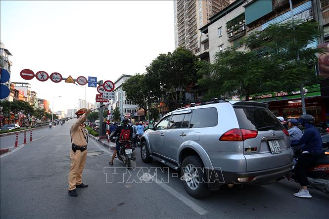 Trong ảnh: Cảnh sát giao thông phân luồng không cho phương tiện lưu thông lên cầu vượt Lê Văn Lương - Láng Hạ khiến giao thông tại khu vực đường Láng ùn tắc kéo dài hàng cây số. Ảnh: Huy Hùng - TTXVN
