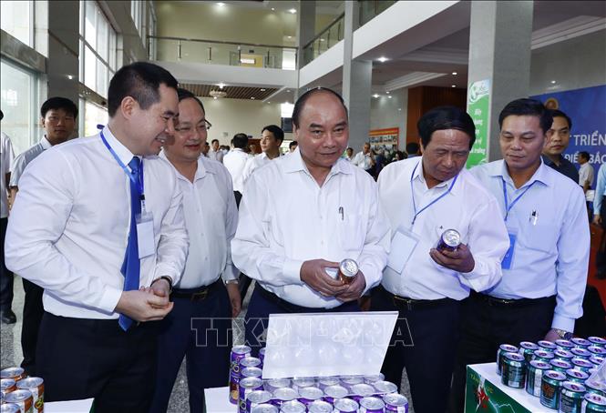 Trong ảnh: Thủ tướng Nguyễn Xuân Phúc và các đại biểu tham quan khu vực trưng bày sản phẩm đặc trưng của vùng đồng bằng Bắc Bộ. Ảnh: Thống Nhất- TTXVN
