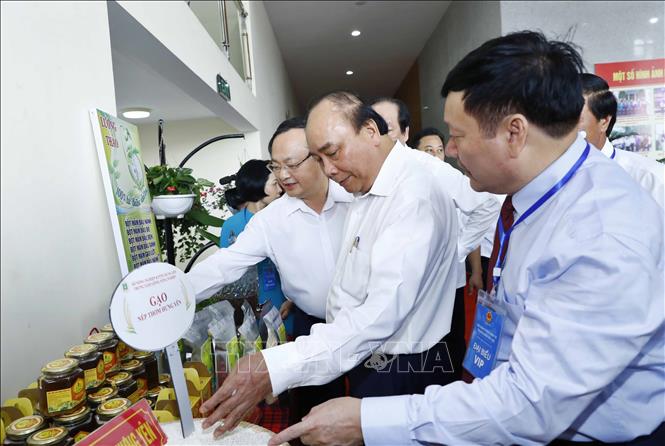 Trong ảnh: Thủ tướng Nguyễn Xuân Phúc và các đại biểu tham quan khu vực trưng bày sản phẩm đặc trưng của vùng đồng bằng Bắc Bộ. Ảnh: Thống Nhất- TTXVN